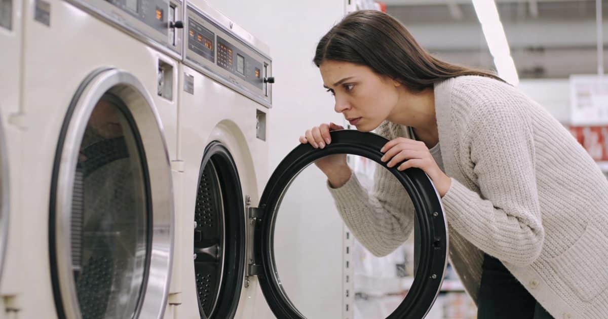 Consommateur pensif comparant deux lave linge en magasin