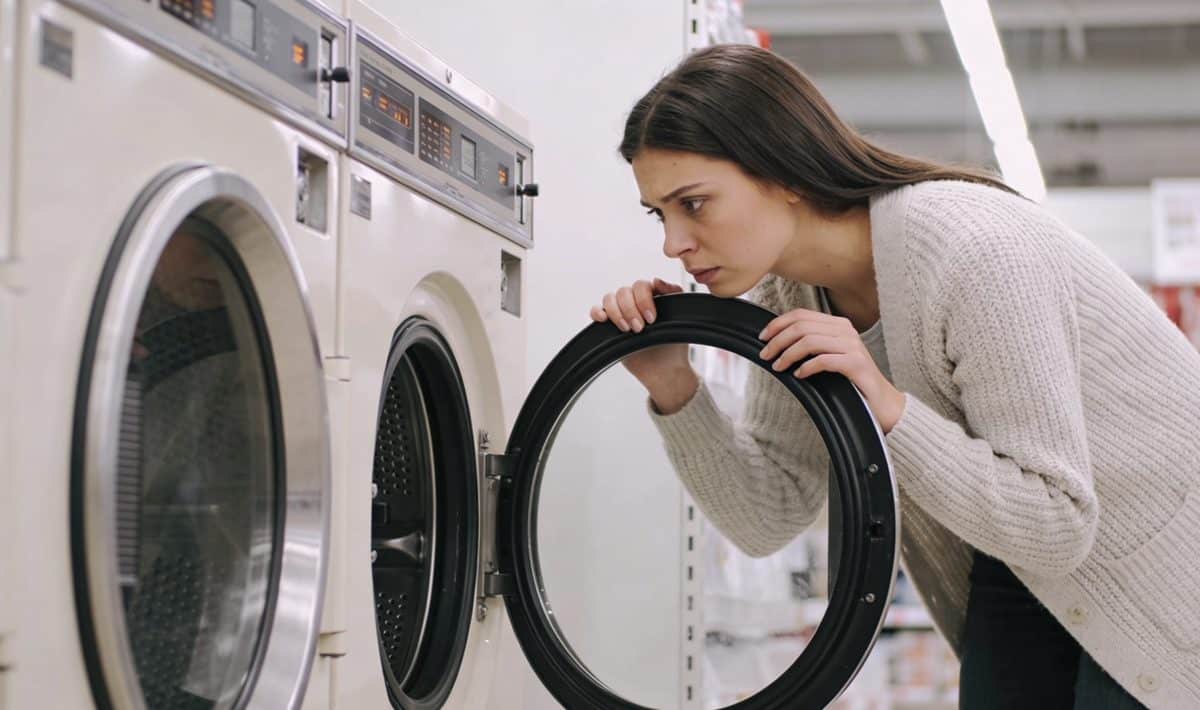 Consommateur pensif comparant deux lave linge en magasin