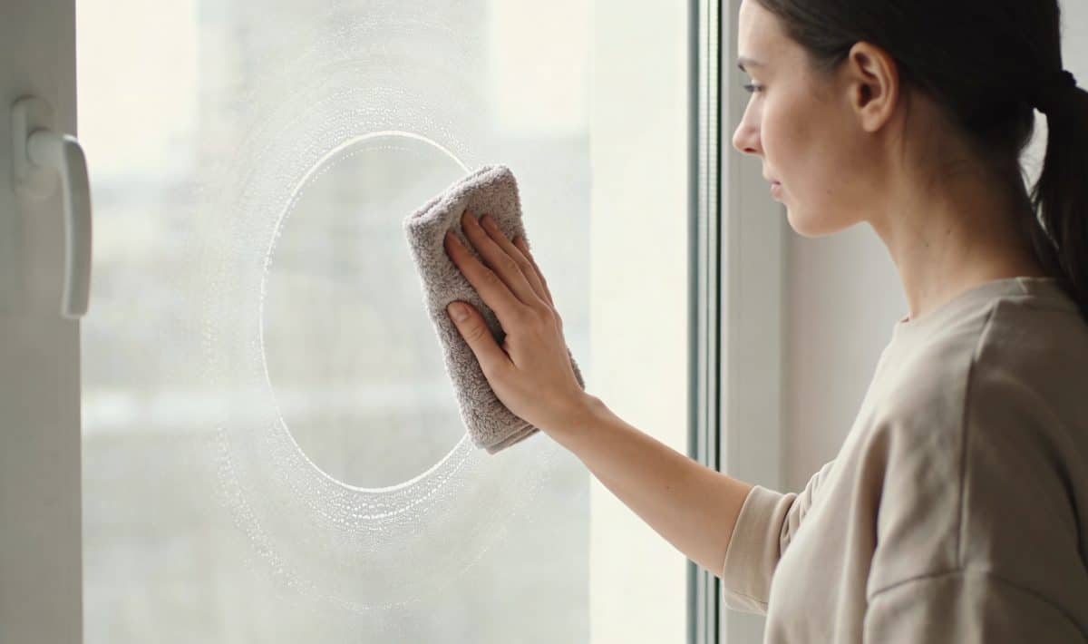 Femme essuyant une grande fenetre avec chiffon en microfibre