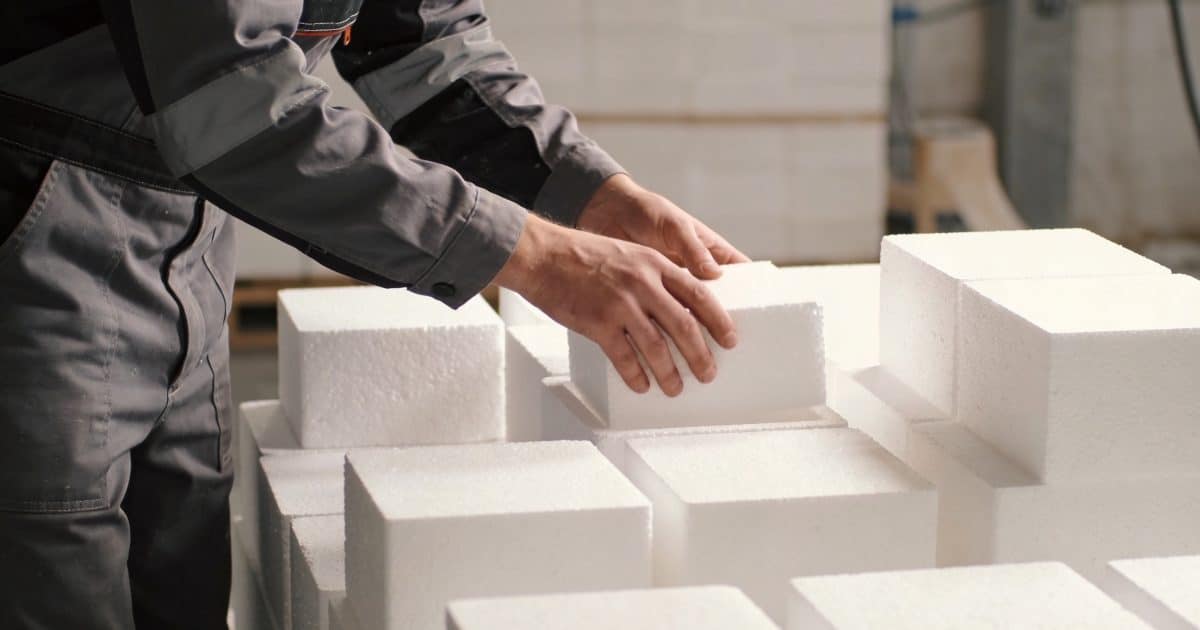 Ouvrier triant des blocs de polystyrene blanc