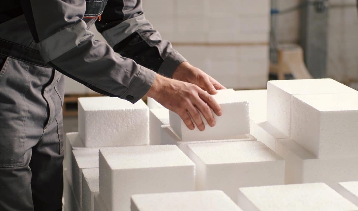 Ouvrier triant des blocs de polystyrene blanc