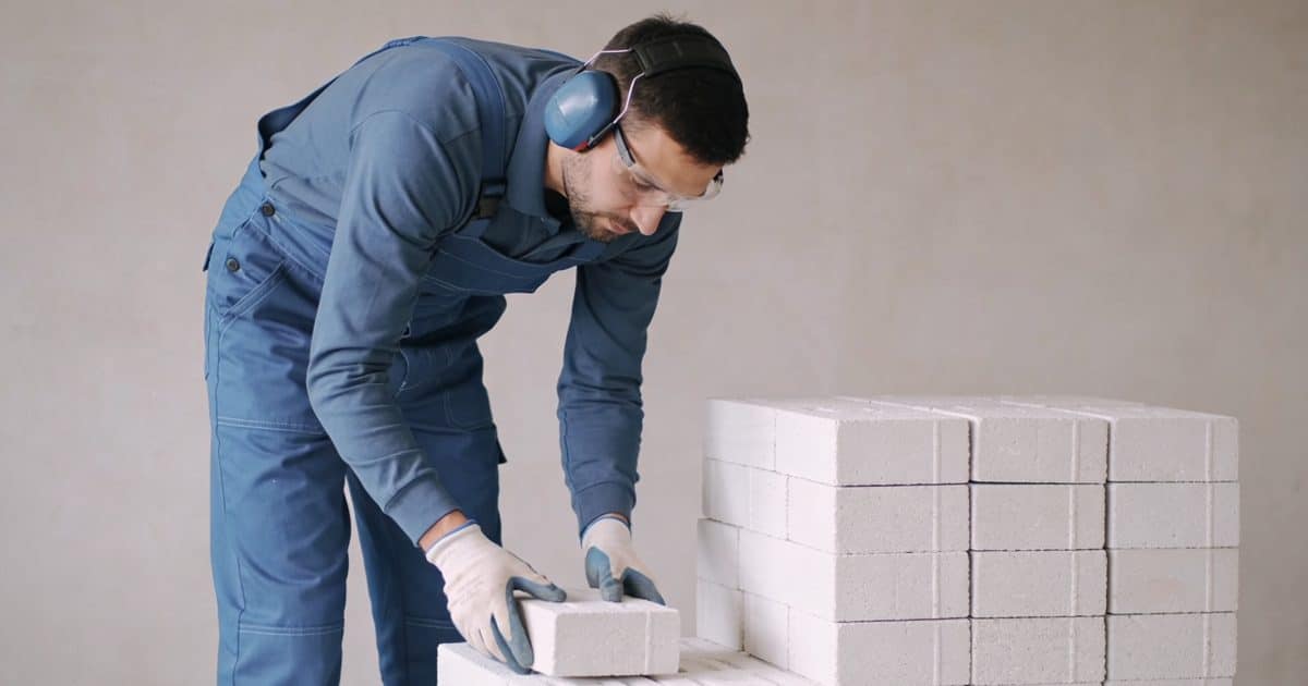 Ouvrier incline triant blocs blancs de polystyrene usage