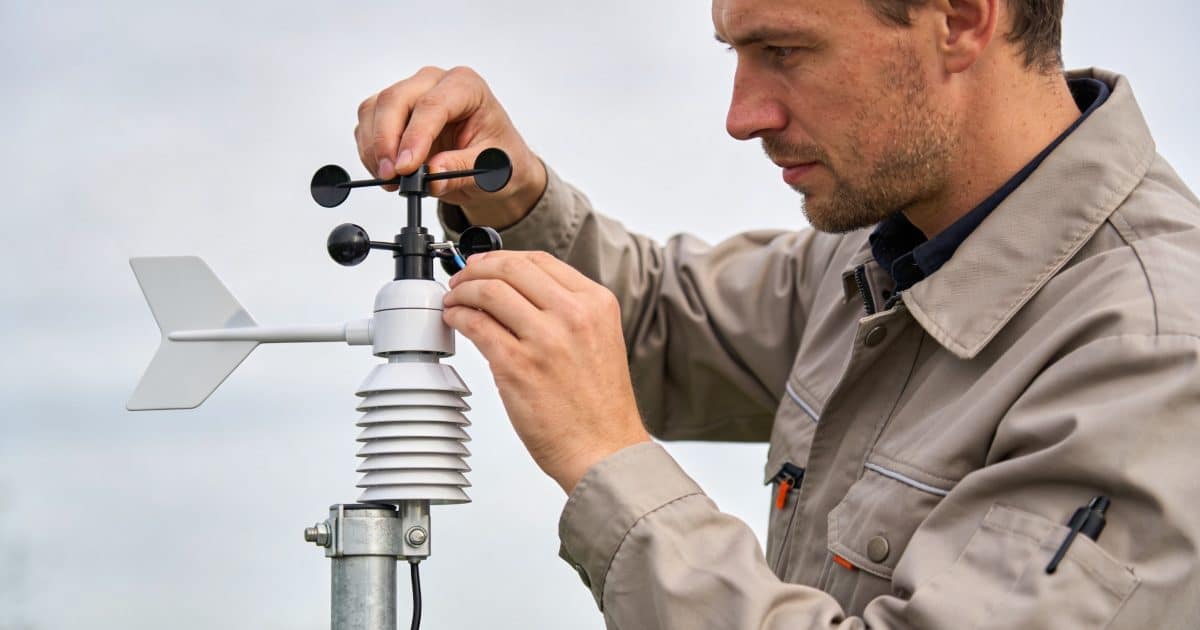 technicien ajuste capteurs sur petite station meteo moderne