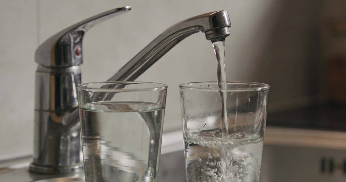 Verres remplis devant robinet cuisine coulant doucement