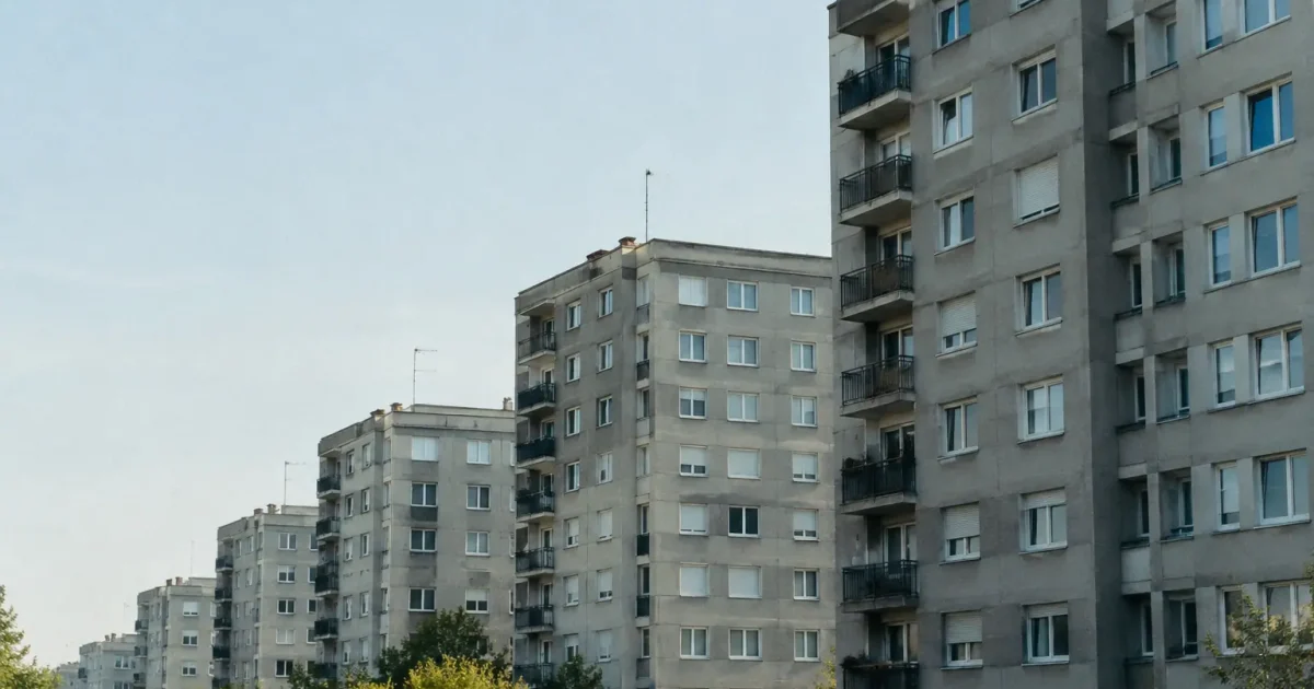 Grands immeubles gris alignes sous un ciel clair