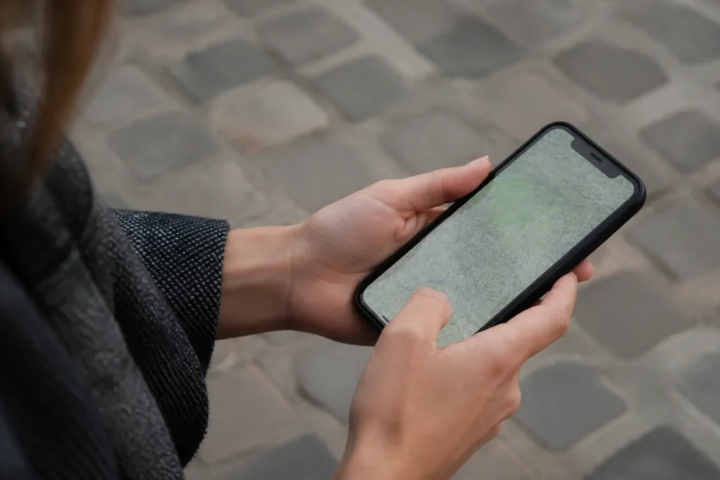Mains tenant un smartphone affichant une carte urbaine