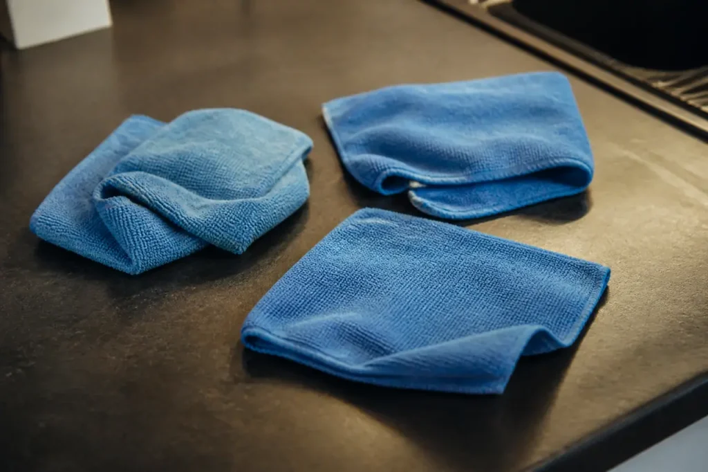 Trois microfibres bleues posees sur un plan de travail
