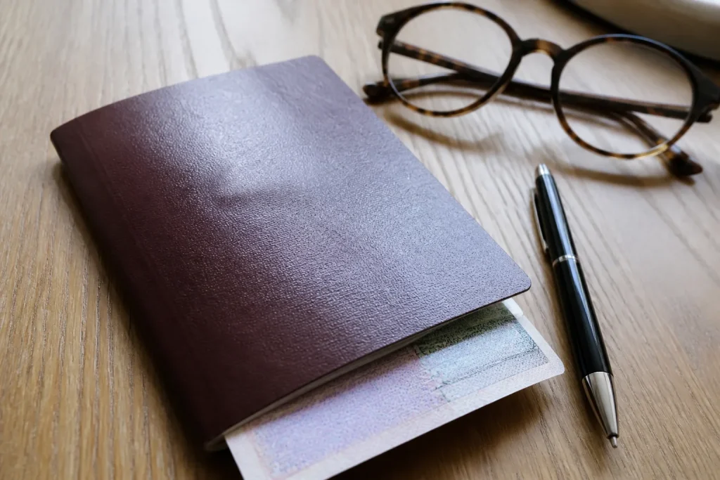 Passeport avec visa, stylo et lunettes sur bureau